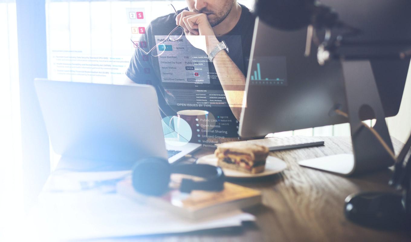 professional working on several document types on a desktop and laptop